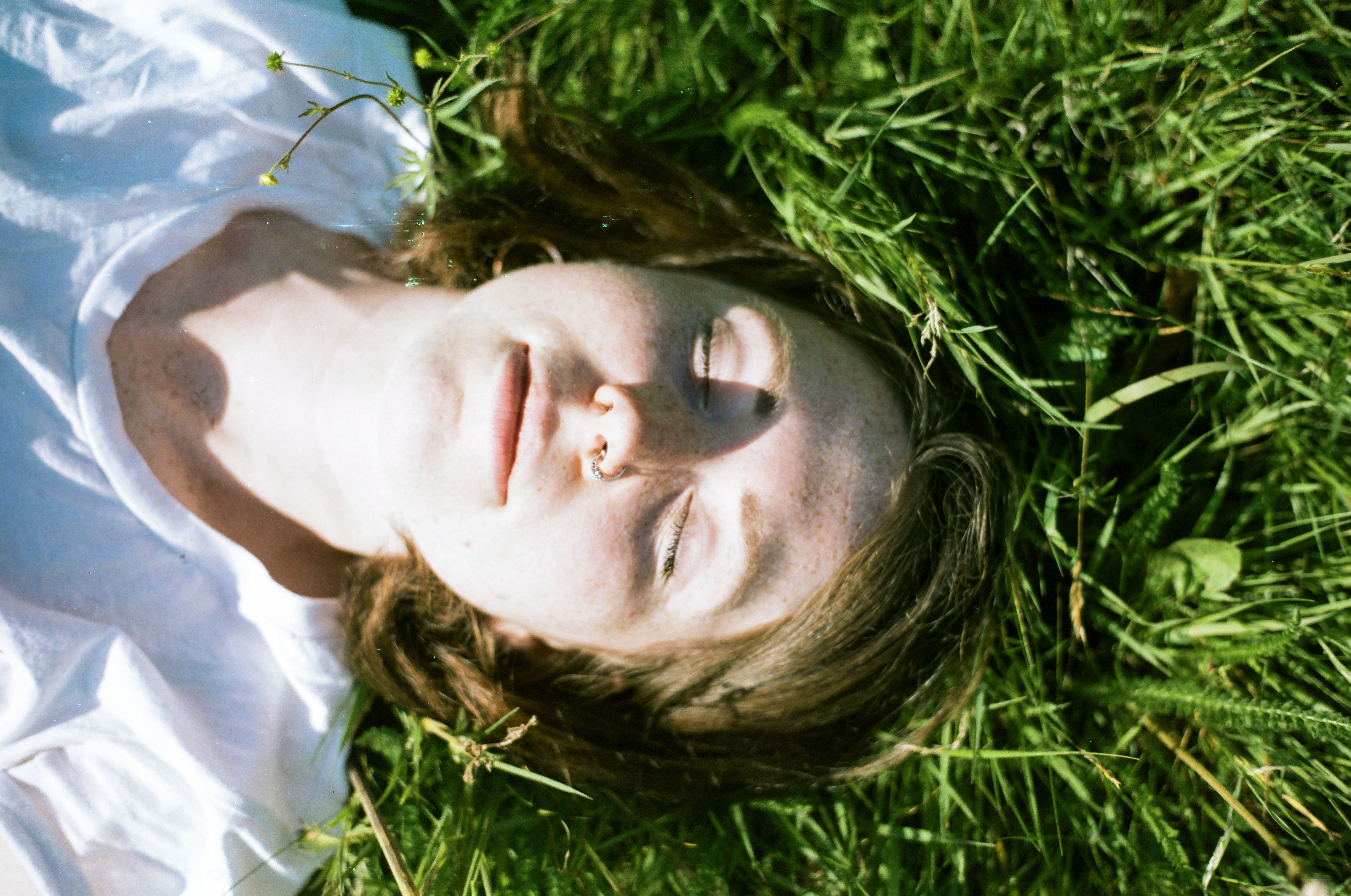 Child lying peacefully on green grass