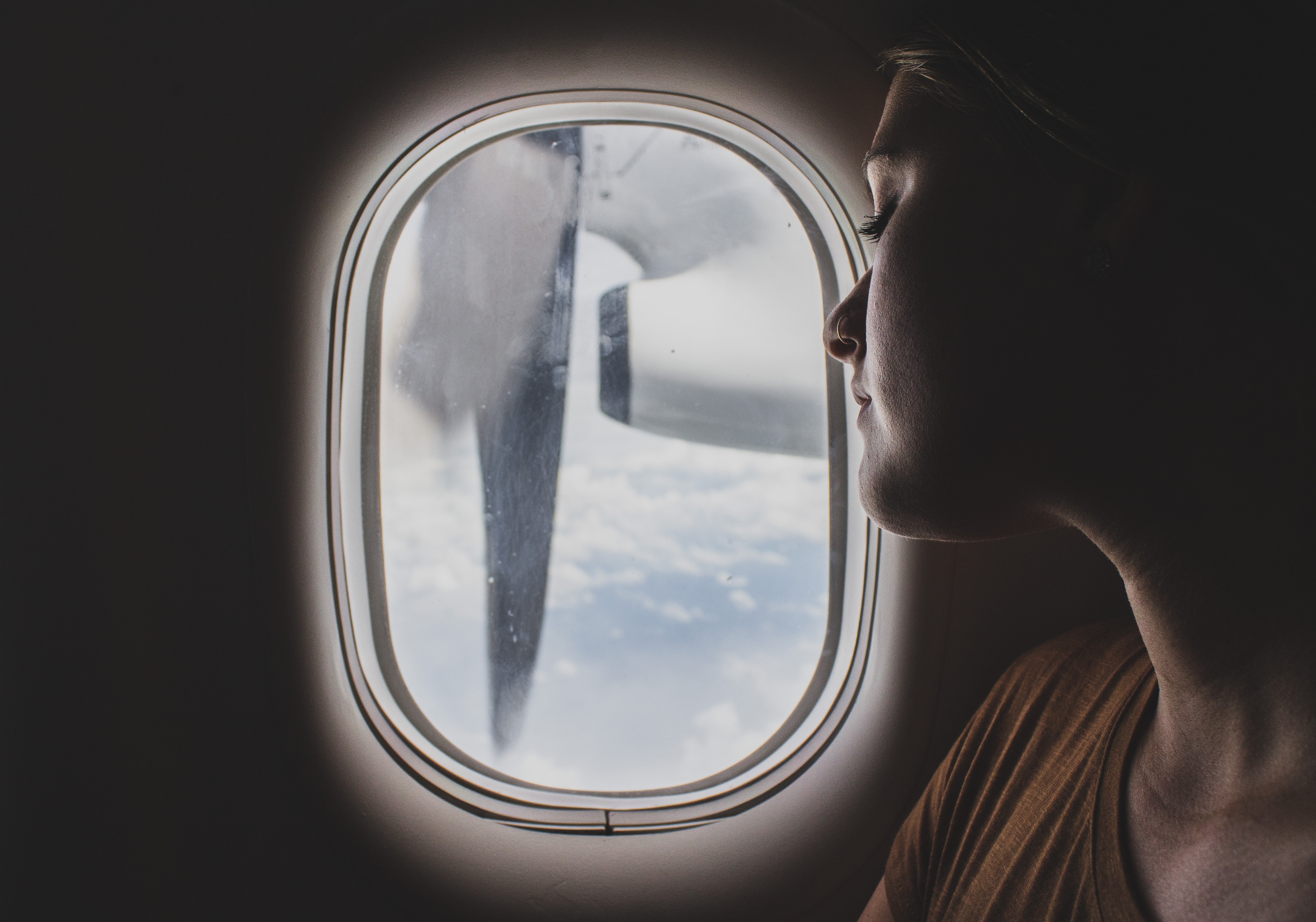 woman sleeping on a plane next to the window