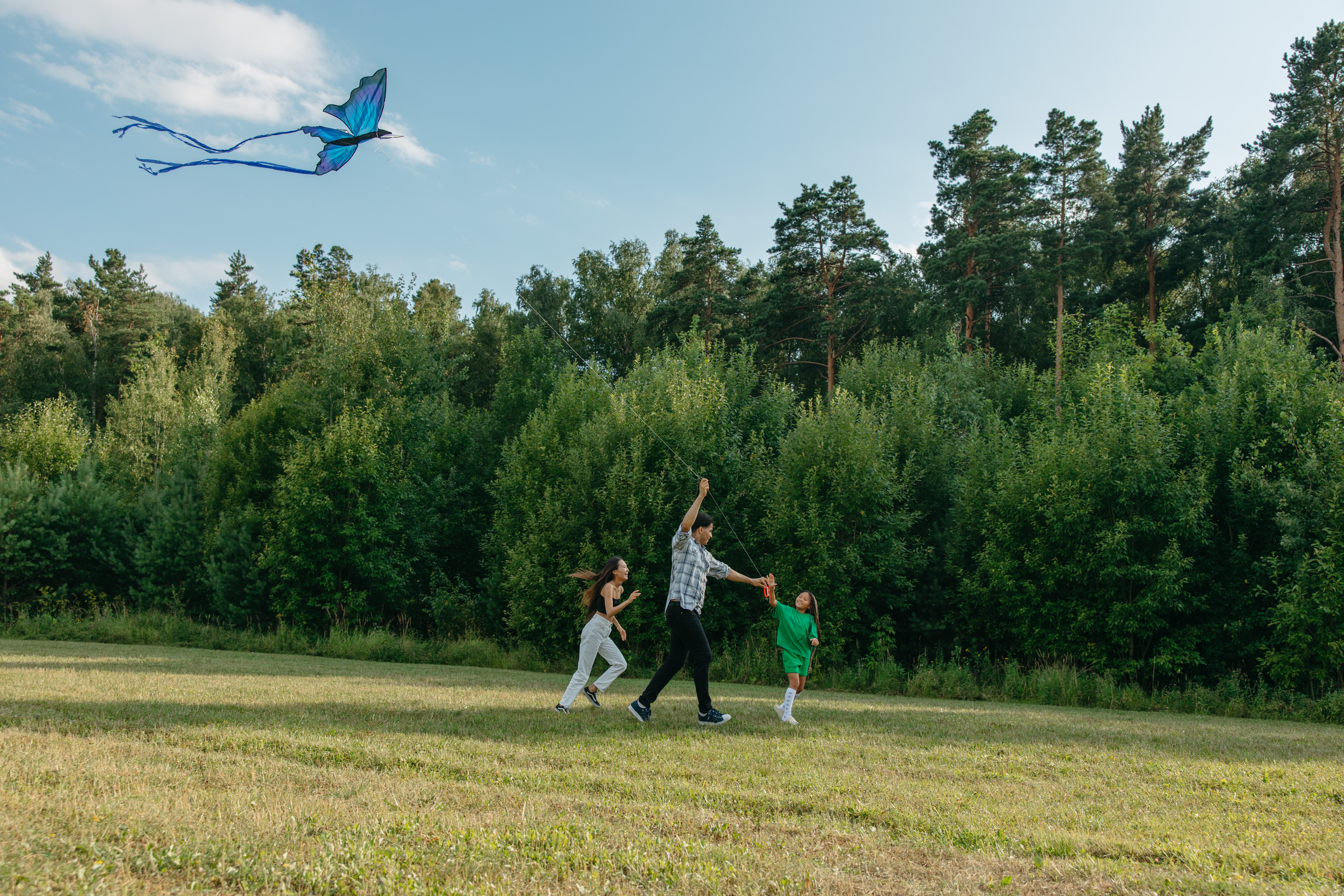 A mother flies a kite with two children