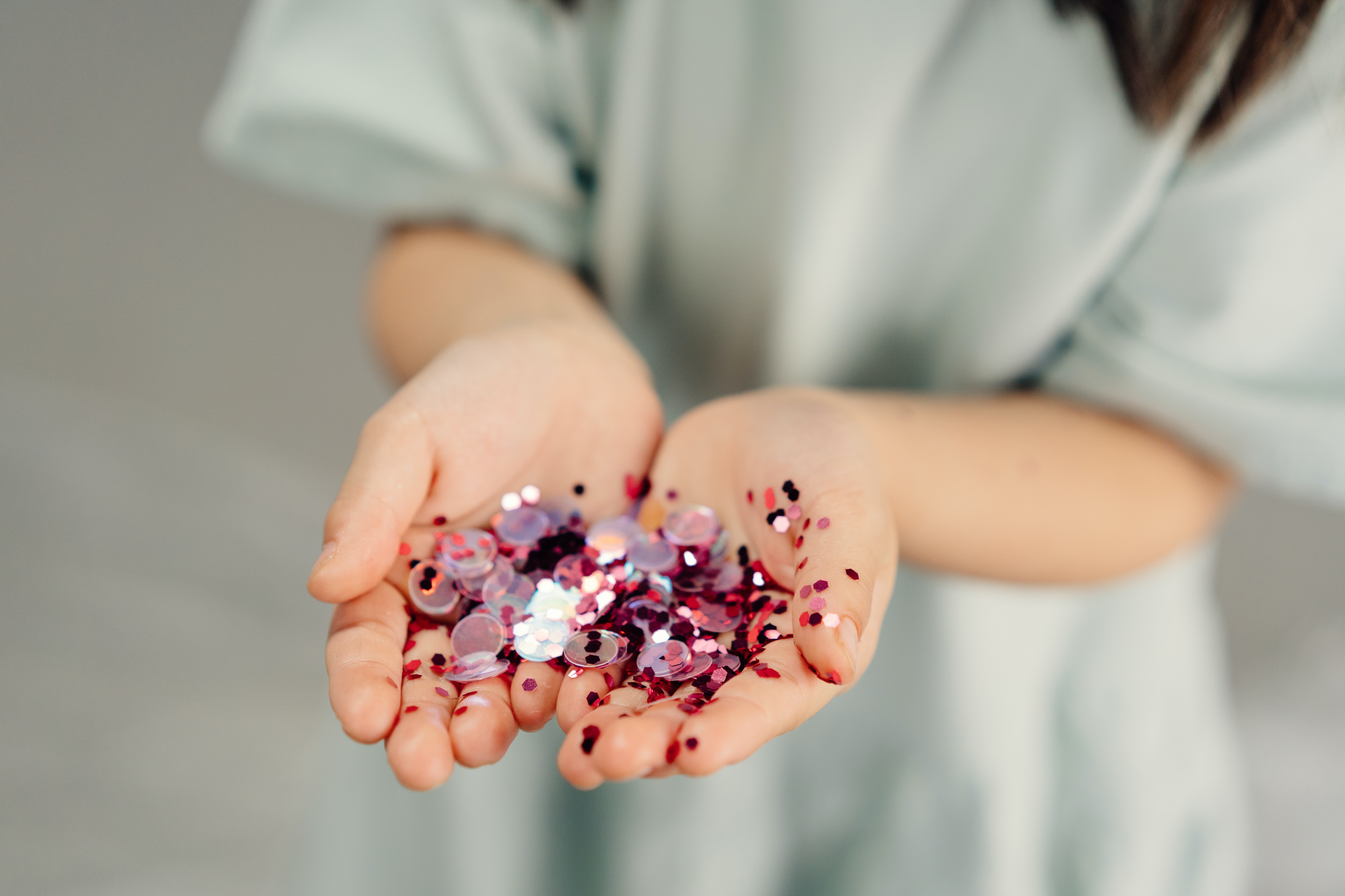 a child holds glitter in their hands