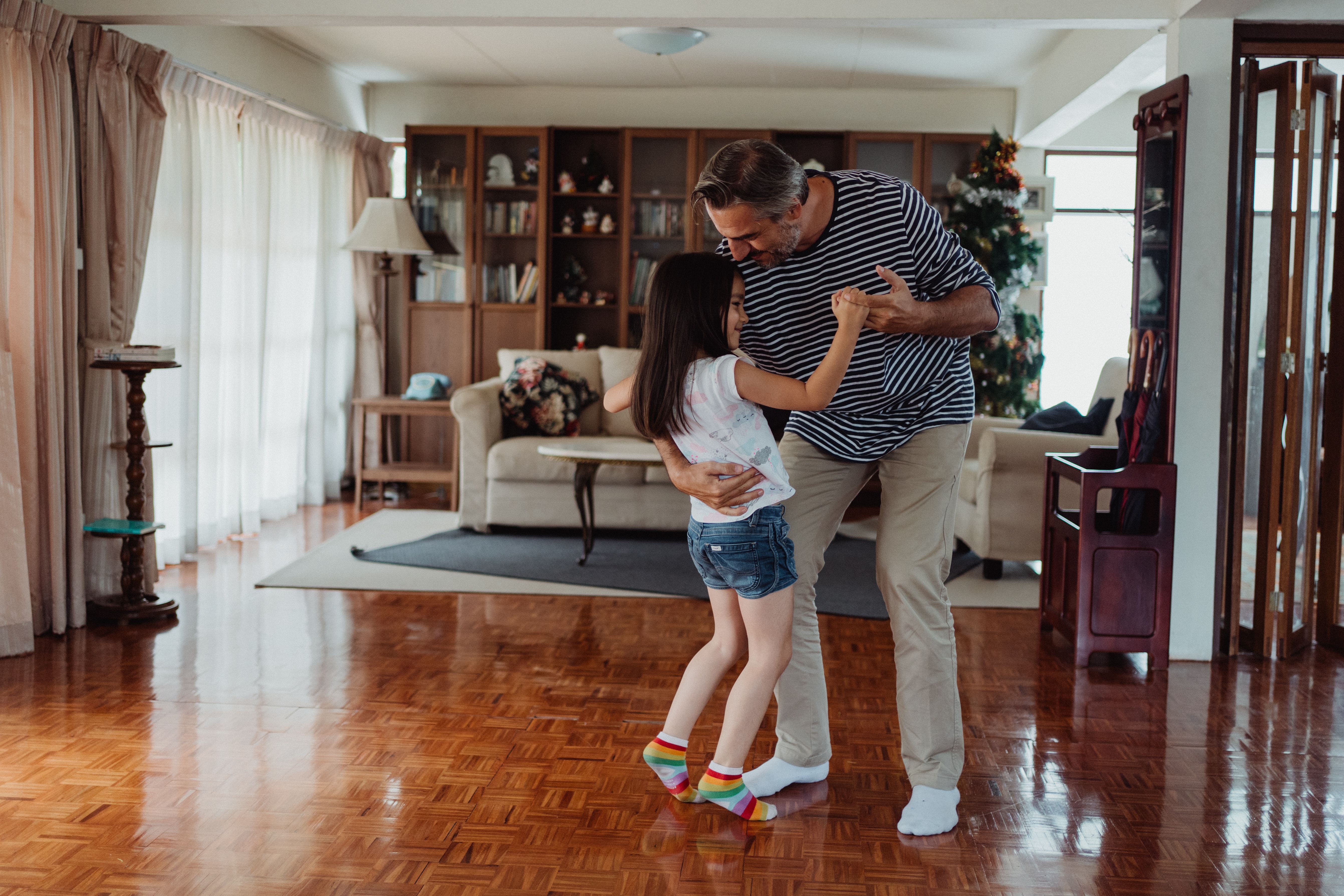 father and daughter dancing together in living room