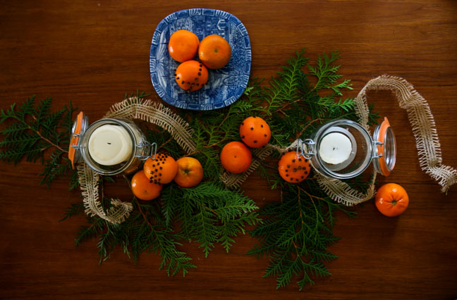 tablescape of pomander, candles, evergreen