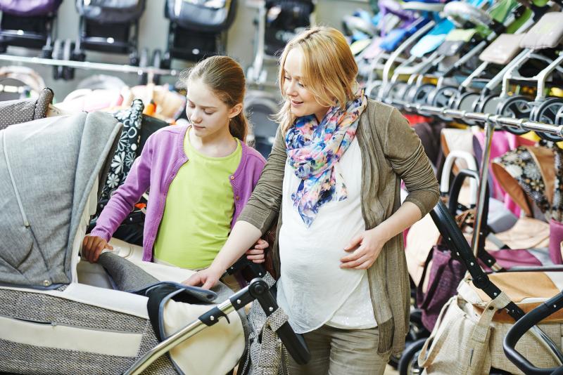 All You Need to Know About Buying Greener Baby Equipment: pregnant woman in a store selecting a stroller