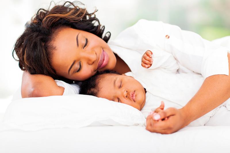 Mom sleeping with shop baby in crib