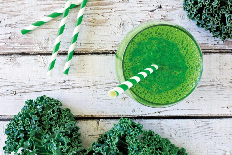 green smoothie with striped green straw viewed from above