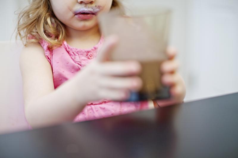 5 Smoothie Moves for Smart Parents Young girl picking up a smoothie glass