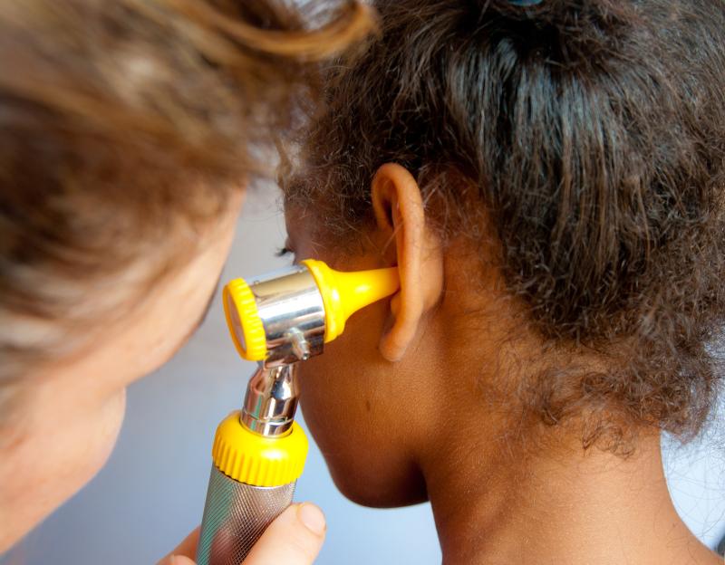 Doctor looking in a child's ear 