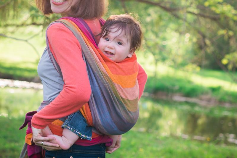 mom carrying baby in a sling on her back