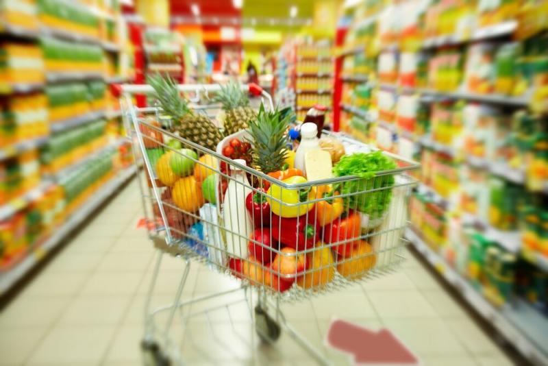 How To Read The Food Labels At Grocery Stores: Loaded grocery cart between aisles at store