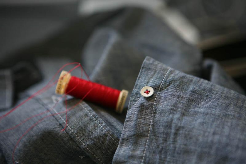 blue shirt with spool of red thread