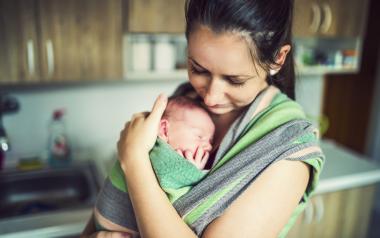 Baby Carrier Selection for Beginners: mom holding newborn in sling carrier