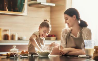 woman and young girl making food at the kitchen counter