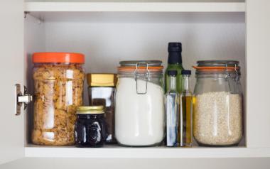 Spring Clean your pantry: Cupboard with jars of dried goods neatly organized inside