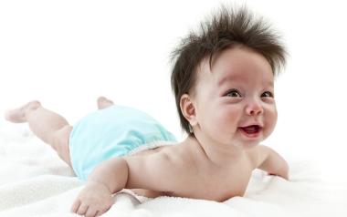 Cloth Diaper Tips and Tricks: cute happy baby with crazy hair lying on stomach in a diaper