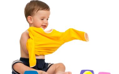 toddler putting on a yellow shirt