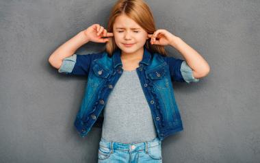 young girl plugging her ears and shutting her eyes