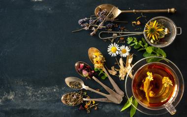assorted herbs and spoons on a black background