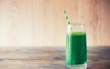 green smoothie with a green striped straw