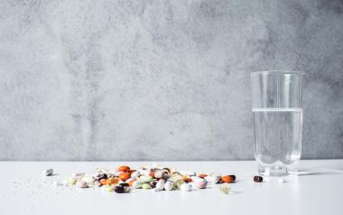 assortment of vitamins and supplements on a table next to a glass of water