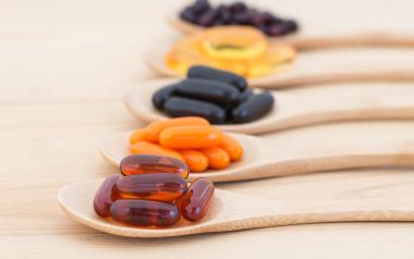 wooden spoons lined up and filled with various vitamins