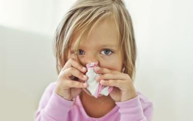 small girl holding a handkerchief over her nose