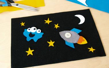 Cosmic Play Mat with rocket, stars, moon, and an alien