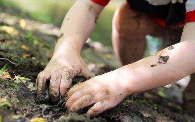 small child playing in the mud