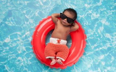 infant floating on an inflatable toy in the pool