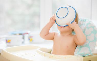 baby drinking from cereal bowl