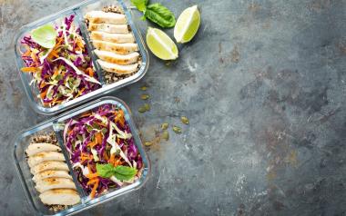 Healthy meal prep containers with quinoa, chicken and cole slaw overhead shot 