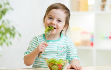 young child eating a healthy salad