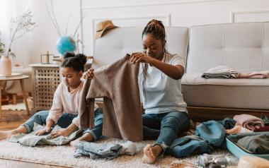 a mom and daughter fold clean laundry