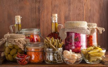 Glass jars of fermented and probiotic-rich foods on a pantry shelf