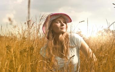 a woman in a sun hat in a field of wheat
