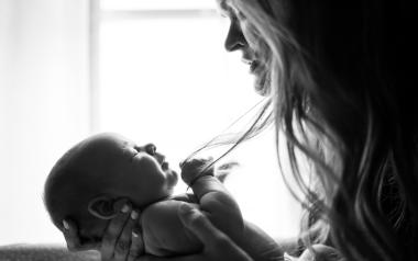 a woman holding her baby looking sad