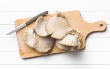 medicinal mushrooms cut on a cutting board next to a knife