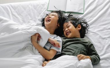 Kids laughing in bed