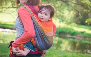 mom carrying baby in a sling on her back