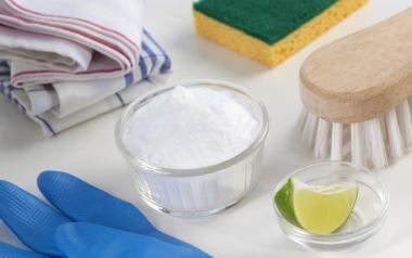 cleaning tools, rubber gloves, rags, lime and baking soda in a bowl