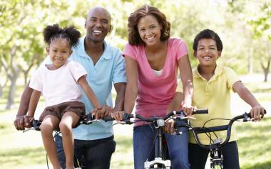 family of four smiling and sitting on bicycles