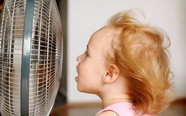little girl keeping cool in front of an electric fan