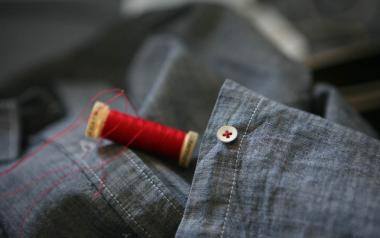 blue shirt with spool of red thread