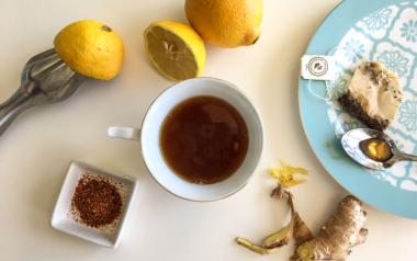 6 Safe and Healthy Ways to Detoxify Your Body: lemons, tea, ginger, spices in a bowl, tea bag and spoon on a patterned plate