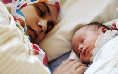 new mom sleeping beside newborn