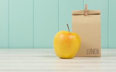 brown bag lunch and yellow apple