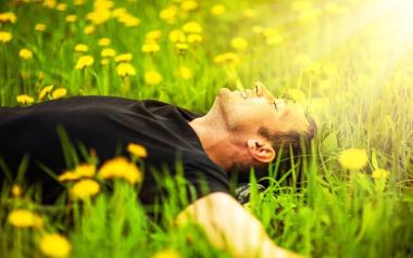 How to treat allergy: Man lying in field of dandelions
