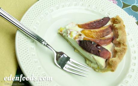 A slice of peach tart on a plate with a forl