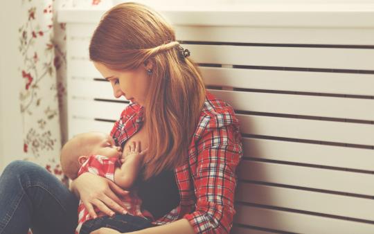 woman in plaid shirt breastfeeding