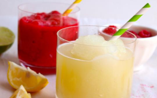 a berry slushie and a lemon slushie with straws