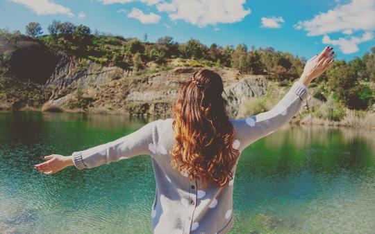 woman enjoying the view of a lake and forest